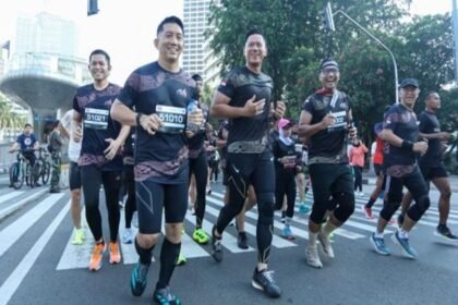 Foto ilustrasi sekelompok pelari berlari bersama di jalan raya perkotaan saat mengikuti ajang lari.