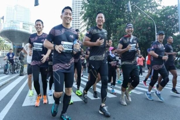 Foto ilustrasi sekelompok pelari berlari bersama di jalan raya perkotaan saat mengikuti ajang lari.