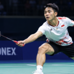 Pemain bulu tangkis menjangkau kok di lapangan indoor dalam ilustrasi Hylo Open 2026.