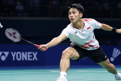 Pemain bulu tangkis menjangkau kok di lapangan indoor dalam ilustrasi Hylo Open 2026.