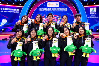 Ilustrasi tim bulu tangkis Indonesia berpose mengenakan medali dan memegang maskot di podium Badminton Asia Team Championships 2026.