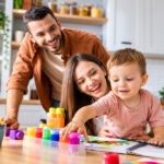 Ayah dan ibu mendampingi anak balita bermain warna dan menggambar bersama di meja rumah.