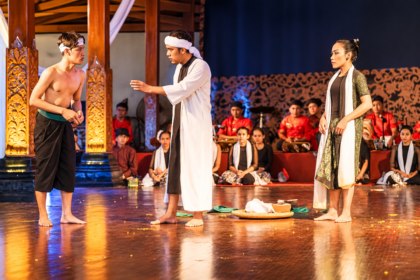 Ilustrasi pertunjukan drama tradisional Jawa dengan tiga pemeran di panggung dan pemain gamelan di latar belakang.