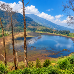 Ilustrasi Telaga Merdada di kawasan Dieng dengan hamparan air, perbukitan hijau, lahan pertanian, dan pepohonan di sekitarnya.
