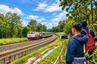 Ilustrasi kereta api KAI melintasi jalur berkelok di tengah pepohonan dengan railfans mengabadikan perjalanan.