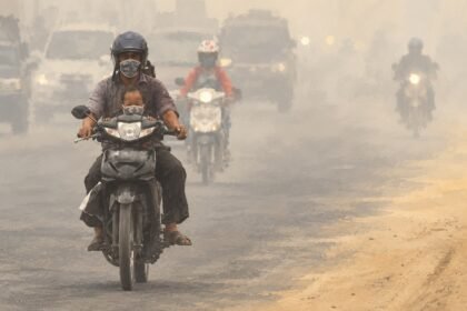 Ilustrasi polusi udara dan kabut asap di jalan raya yang mengganggu jarak pandang pengendara sepeda motor.