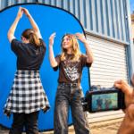 Ilustrasi dua anak muda menampilkan gerakan tari di depan latar biru dalam kegiatan seni dan kreativitas dengan fotografer.