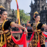 Penari tradisional berbaju hitam dan emas dengan selendang merah tampil di pelataran candi bersejarah