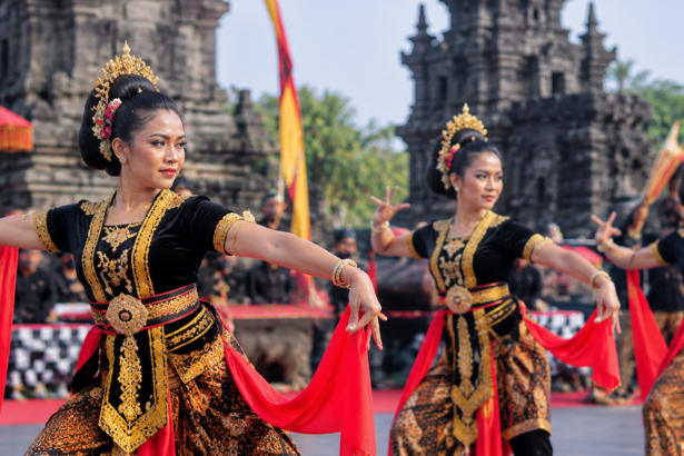 Penari tradisional berbaju hitam dan emas dengan selendang merah tampil di pelataran candi bersejarah