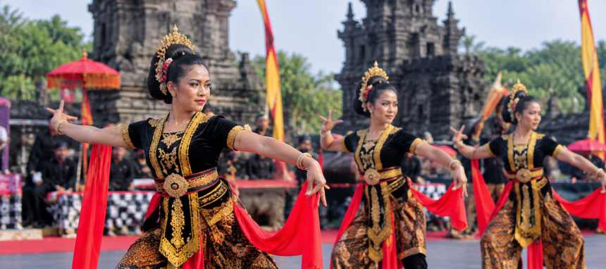 Penari tradisional berbaju hitam dan emas dengan selendang merah tampil di pelataran candi bersejarah