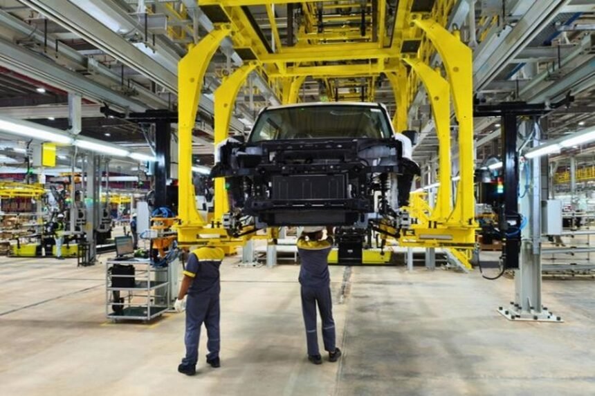 Proses perakitan mobil di pabrik otomotif modern dengan bantuan mesin dan pekerja.