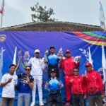 Atlet berdiri di podium juara bersama tim pendukung dalam kejuaraan olahraga