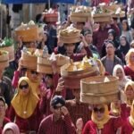 Ilustrasi warga mengikuti tradisi Nyadran dengan membawa hasil bumi dan makanan dalam wadah anyaman bambu.