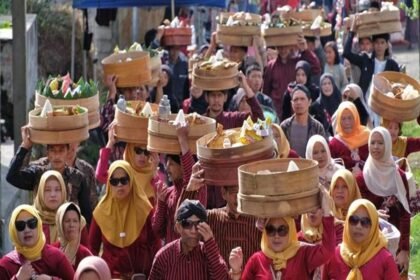 Ilustrasi warga mengikuti tradisi Nyadran dengan membawa hasil bumi dan makanan dalam wadah anyaman bambu.
