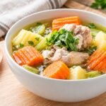 Sup ayam dengan wortel, kentang, dan sayuran dalam kuah bening hangat